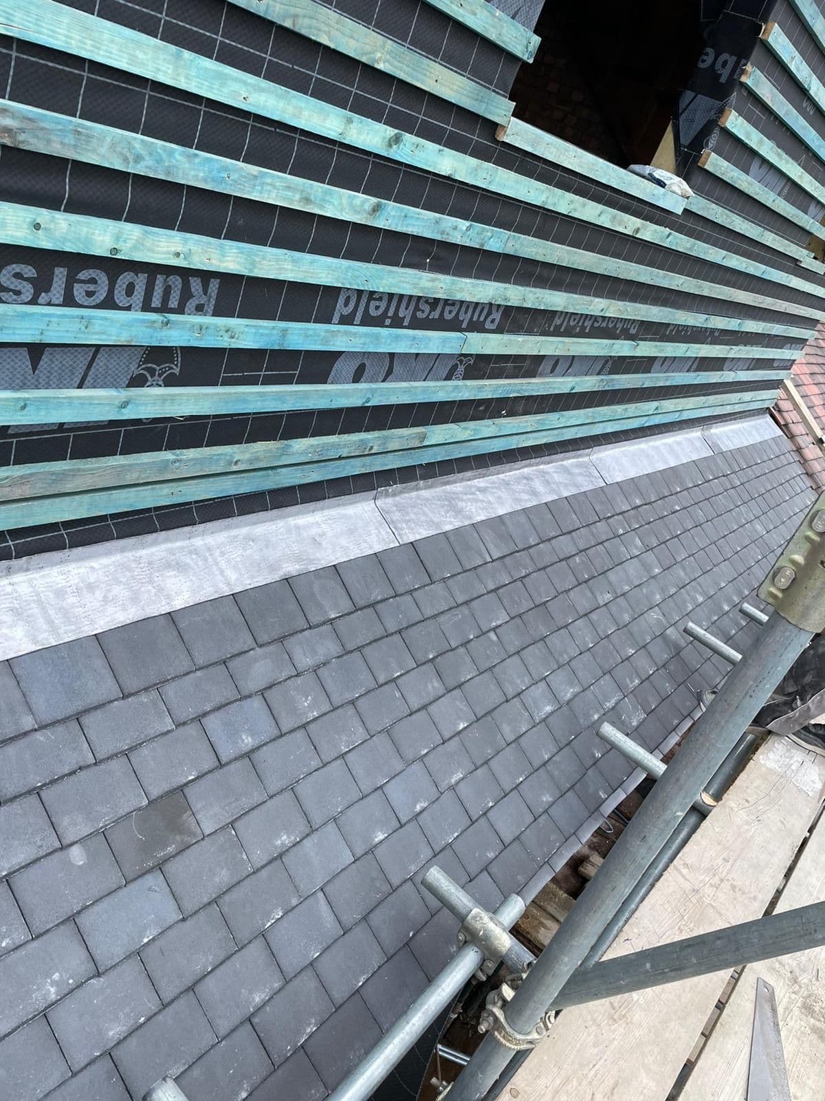 Slate roof installation in progress with breathable membrane, battens and leadwork by Delta Construction